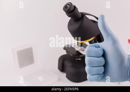 a laboratory assistant in blue gloves shows class with his hand Stock Photo