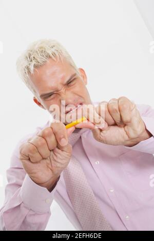 Close up of a businessman trying to break a pencil Stock Photo