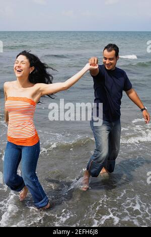 Young couple standing on the beach and smiling Stock Photo