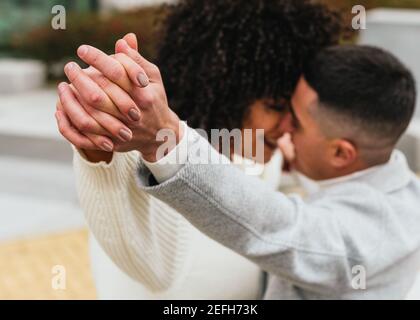 Shallow focus of a young romantic couple dancing and kissing outdoors Stock Photo