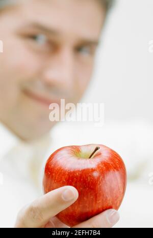 Portrait of a mature man holding an apple Stock Photo