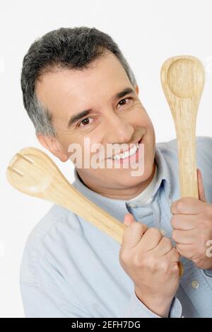 Portrait of a mid adult man holding salad servers Stock Photo