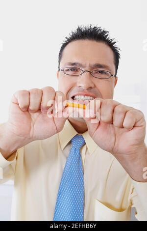 Portrait of a businessman trying to break a pencil Stock Photo