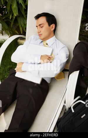 Businessman sleeping on a lounge chair Stock Photo