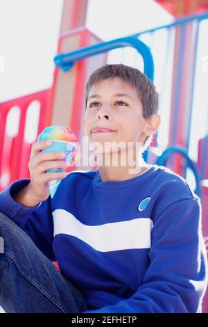 Close up of a teenage boy holding an ice cream cone Stock Photo