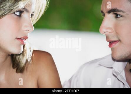 Close up of a teenage boy looking at a young woman Stock Photo