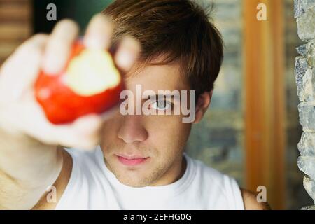 Portrait of a young man showing a partially eaten apple Stock Photo