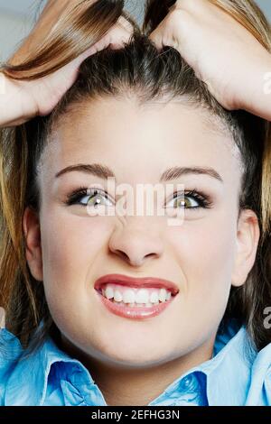 Portrait of a teenage girl clenching her teeth and pulling her hair Stock Photo