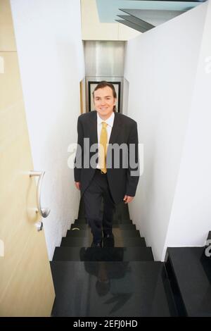 Portrait of a businessman walking up stairs Stock Photo