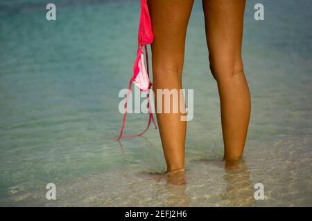 Low section view of a young woman holding a bikini top Stock Photo