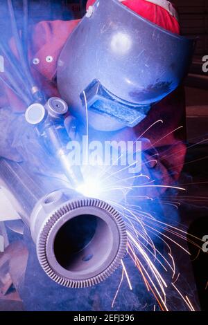 Close-up of a welder welding a pipe Stock Photo