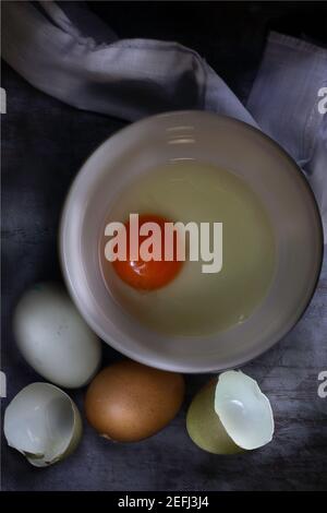 Flat lay of raw eggs and yolk in bowl Stock Photo