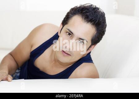 Portrait of a young man reclining on a couch Stock Photo