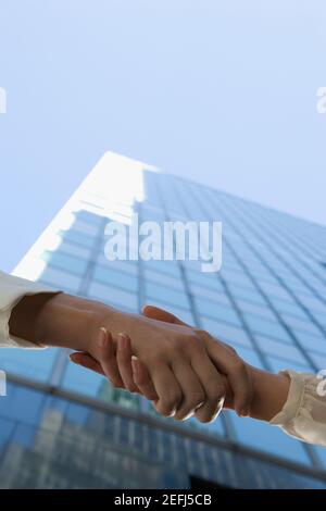 Low angle view of two people shaking hands Stock Photo