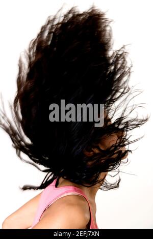 Side profile of a young woman tossing her hair Stock Photo