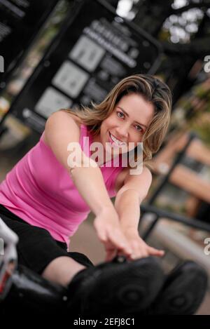 Portrait of a young woman doing sit-ups and touching her toes Stock Photo