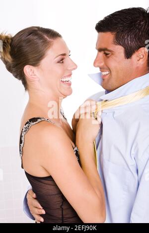 Side profile of a young woman pulling a mid adult manÅ½s tie Stock Photo