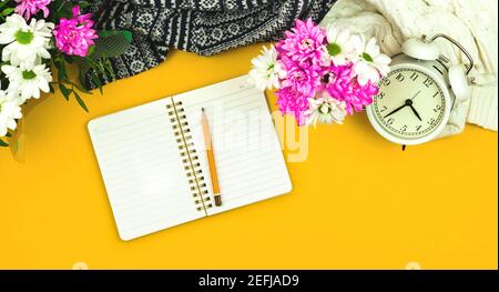 Blank notepad with pencil, spring composition on yellow background with flowers, women's day holiday theme photo Stock Photo