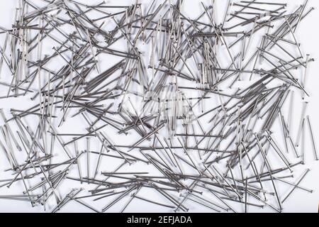Little metal nails on a white background, for working with wood. Stock Photo