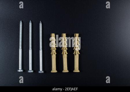 Dowels with self-tapping screw on black background with copy space. Stock Photo