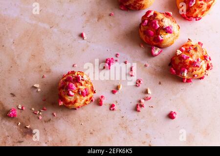 Freshly baked French chouquettes topped with pink almond pralines. Stock Photo