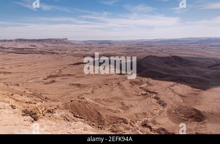 view of Mount Ardon and Givat Gaash in the Makhtesh Ramon crater in Israel from the Gaash Overlook with a beautiful partly cloudy sky in the backgroun Stock Photo