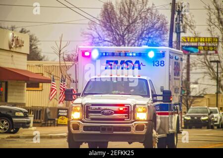 2-1-2019 Tulsa USA - Oncoming EMSA ambulance with lights blazing on urban street on overcast day - selective focus Stock Photo