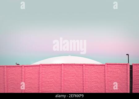 Modern architecture, UFO behind a pink brick wall Stock Photo