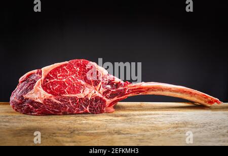 Dry aged wagyu tomahawk steak on a wooden cutting board Stock Photo