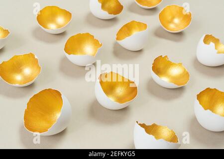 Gold on beige color combination. Golden eggshell as a concept of constant profit. Modern easter background for advertising banner. Abstract Easter sti Stock Photo