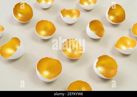 Golden eggshell on an ecru background. The concept of the modern vision of Easter. Happy Easter advertising banner. Abstract still life from eggshell. Stock Photo