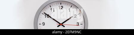 Simple modern wall clock in silver color frame, isolated on white background.House Interior .big round clock hanging on a wall. copy space, deadline Stock Photo
