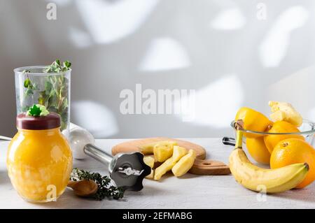 Peeled ginger root on the table. The shadow of the trees from the window on the wall. Kitchen. Stock Photo