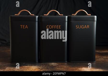 Set of 3 Storage Tins for housing teas, coffee and sugar. Set of three black Storage Jars Stock Photo
