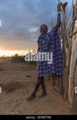 Portrait of Hamer Man At Sunrise: Hamer man in a field where the tribe's cattle graze. Being primarily pastoralists, the Hamer, or Hamar group prizes Stock Photo