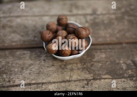 macadamia nuts isolated on a wooden background with copy space Stock Photo