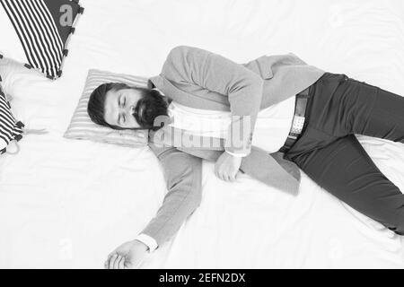 Recovery and recharging. Feel tired and sleepy. Sleepy guy in formal clothes sleep bed top view. Lack of sleep. Need more sleep. Evening time. Businessman exhausted. Sleeping in fashionable clothes. Stock Photo