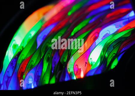 Сoiled LED strip lights glow in the dark, close up photo with selective focus Stock Photo