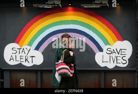 London, England, UK. 17th Feb, 2021. Two women walk past a graffiti with the message 'Stay alert, save lives' in London's Soho district as the coronavirus lockdown continues in the city. UK Prime Minister Boris Johnson is expected to announce the roadmap out of lockdown in the country next Monday. Credit: Tayfun Salci/ZUMA Wire/Alamy Live News Stock Photo