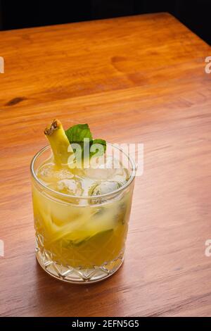 Fruit mixology with pineapple garnish on the wooden table. Stock Photo