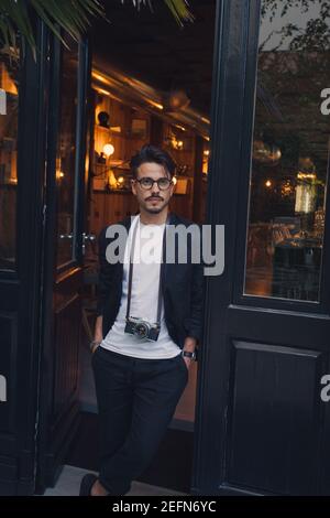 Young man with vintage camera leaving design Hotel Tipografia Do Conto in Porto Portugal Stock Photo