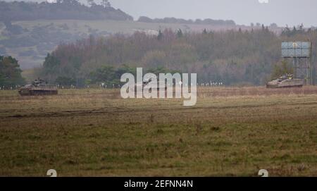 Three British Army Warrior light infantry fighting vehicle FV 510 battle tanks on maneuvers in a demonstration of firepower, Salisbury Plain Stock Photo