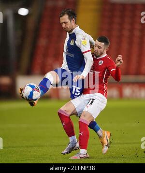 Blackburn Rovers' Barry Douglas (left) and Barnsley's Conor Chaplin battle for the ball during the Sky Bet Championship match at Oakwell, Barnsley. Picture date: Wednesday February 17, 2021. Stock Photo