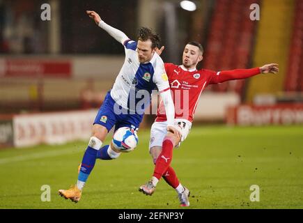 Blackburn Rovers' Barry Douglas (left) and Barnsley's Conor Chaplin battle for the ball during the Sky Bet Championship match at Oakwell, Barnsley. Picture date: Wednesday February 17, 2021. Stock Photo