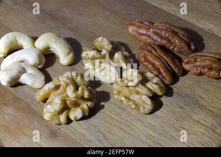 different nuts on wooden table. Cashew,walnut,pecan nut Stock Photo