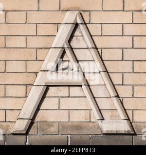 Capital letter A in light brick on beige clinker wall Stock Photo