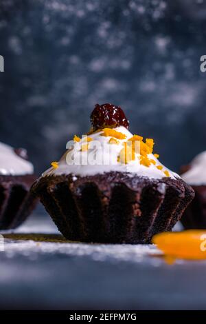 chocolate muffins sprinkled with goodies with cherries and chocolate and cocoa Stock Photo