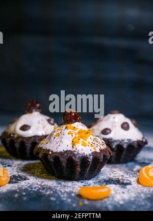 chocolate muffins sprinkled with goodies with cherries and chocolate and cocoa Stock Photo