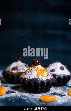 chocolate muffins sprinkled with goodies with cherries and chocolate and cocoa Stock Photo