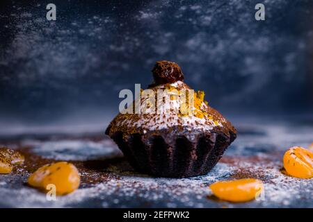 chocolate muffins sprinkled with goodies with cherries and chocolate and cocoa Stock Photo